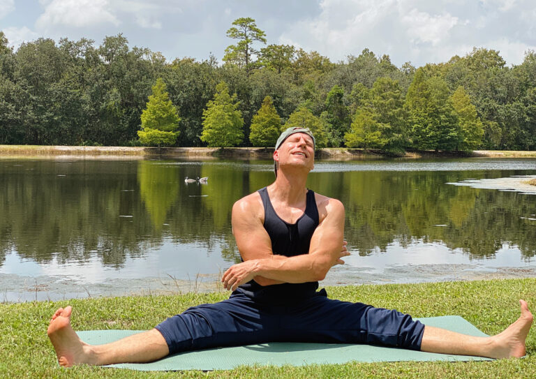 Photo of Sean Vigue stretching out near a lake in Florida